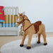 Plush standing ride-on horse toy with saddle in a nursery room on a white rug
