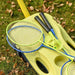 Portable badminton set with rackets and shuttlecocks on grass, yellow suitcase kit.