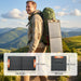 Man hiking with backpack and portable solar panel charger in mountainous landscape at sunset
