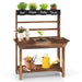 Wooden kids garden potting bench with herb shelf, tools, yellow watering can, and planting station