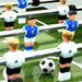 Close-up of professional foosball table with white and blue players on green field
