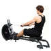 Person using a rowing machine on a white background