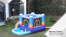 Rainbow inflatable bouncy castle 2-in-1 trampoline and pool on lawn near house