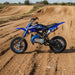 Blue 49cc kids mini dirt bike on outdoor off-road motocross track
