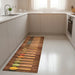 Modern kitchen with white cabinets and floor mat featuring wooden spoons with colorful spices on wooden floor background