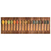 Row of wooden spoons with various colorful spices and herbs on wooden surface