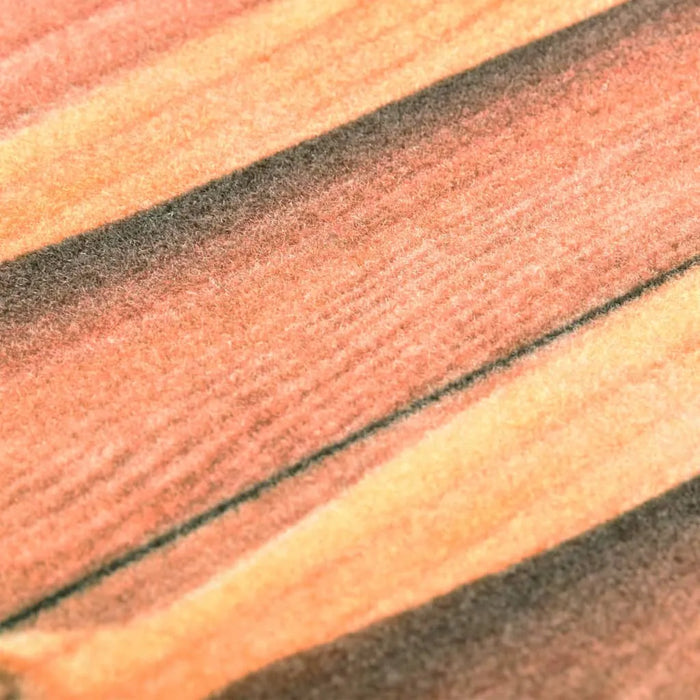 Close-up of rectangular floor mat with orange, brown, and beige velvet surface striped pattern
