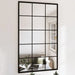 Large wall mirror with a black grid frame on a white wall