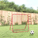 Red football kickback rebounder with steel frame and net on grass, soccer ball in front