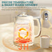 Electric kettle with clear LED display and water heating indicator, next to a cup of coffee.