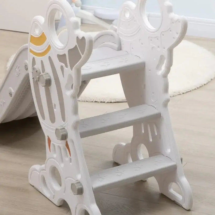 Grey space-themed toddler slide with rocket design and non-slip steps on wood floor