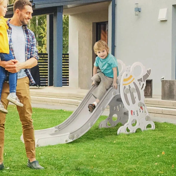 Child plays on grey space-themed toddler slide with non-slip steps in backyard