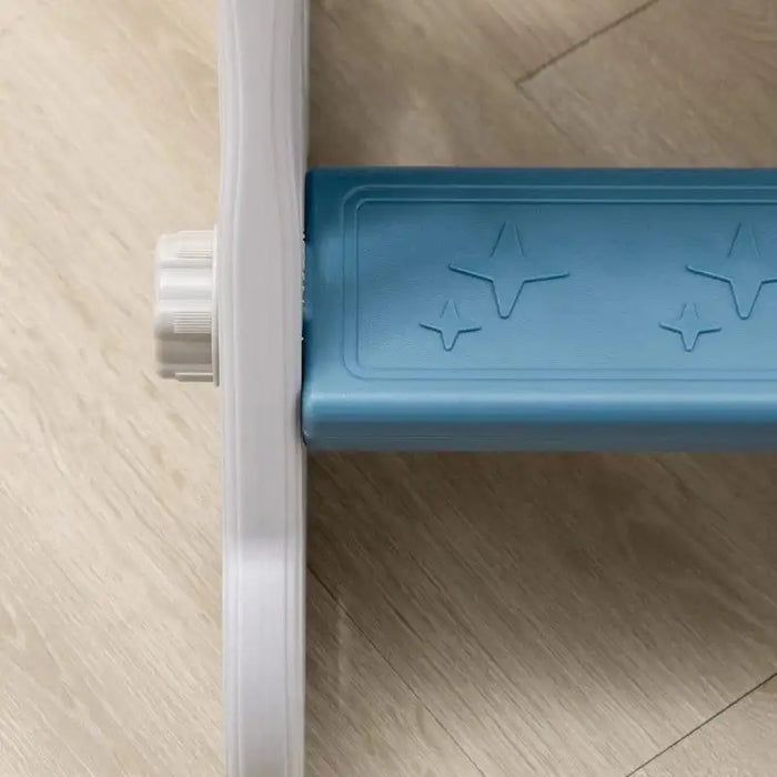 Close-up of blue rocket-themed toddler slide step with star patterns on light wood floor