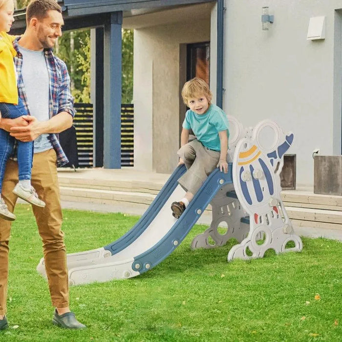 Rocket-themed blue toddler slide with stickers in backyard, child playing outdoors