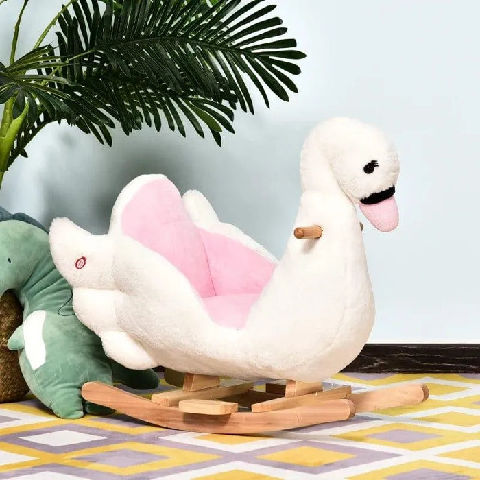 Plush white and pink swan rocking horse for kids on patterned rug with palm leaf plant