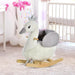 Plush white and grey swan rocking horse with crown in a modern nursery room
