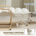 Adjustable footstool with beige cushion and wooden frame in a minimalistic room.
