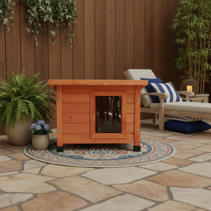 Rustic brown wooden outdoor cat house with flap door on patio, surrounded by plants and lounge chair.