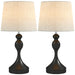 Two table lamps with black bases and white lampshades on a white background