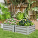Two grey metal raised garden beds with pink and blue flowering plants in a tropical backyard setting