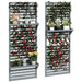 Set of 2 grey wooden wall-mounted plant stands with trellis, decorated with climbing red and pink flowers and assorted potted plants