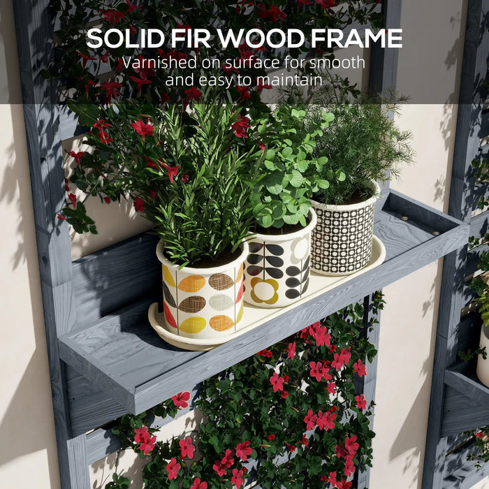 Grey wooden wall-mounted plant stand with trellis holding three patterned cream pots with green plants and red flowers