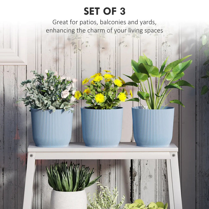 Set of 3 stackable blue plastic plant pots with indoor and outdoor green and flowering plants on white wooden shelf