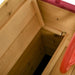 Wooden storage bench inside ship sandbox with red trim detail
