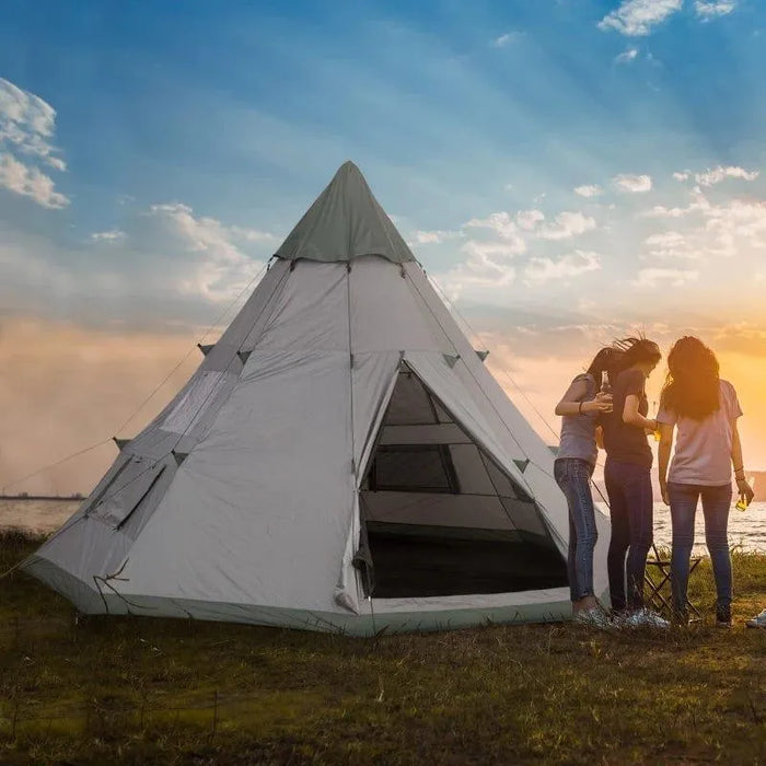 Six-person grey tipi tent with group of people camping near water at sunset