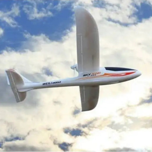 Sky King 750mm RC glider soaring in a blue sky with clouds, WL Toys beginner aircraft