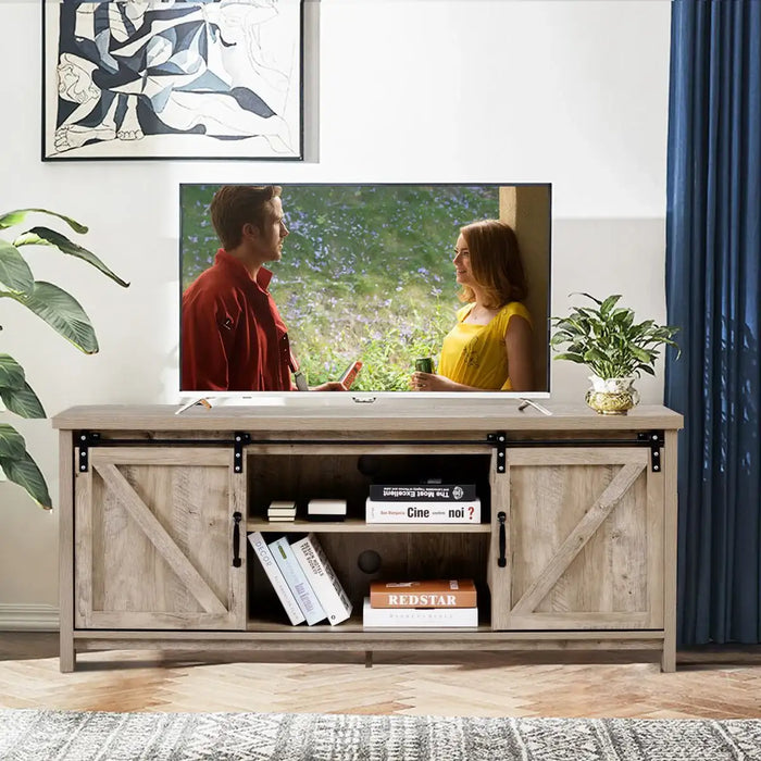 Sliding barn door TV stand with rustic wood finish holding a flat-screen TV and books in modern living room