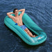 Man relaxing on turquoise mesh floating lounger with cup holder on water outdoors