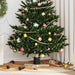 Decorated Christmas tree with red, gold, and green baubles and gold bead garland in cozy living room