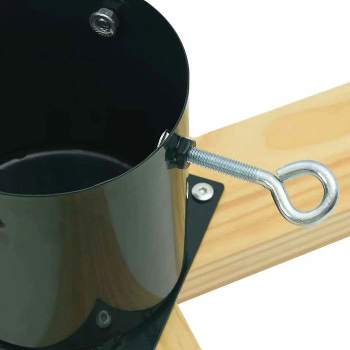 Close-up of a black metal cylinder attached to a wooden base with screws and a metal eye bolt