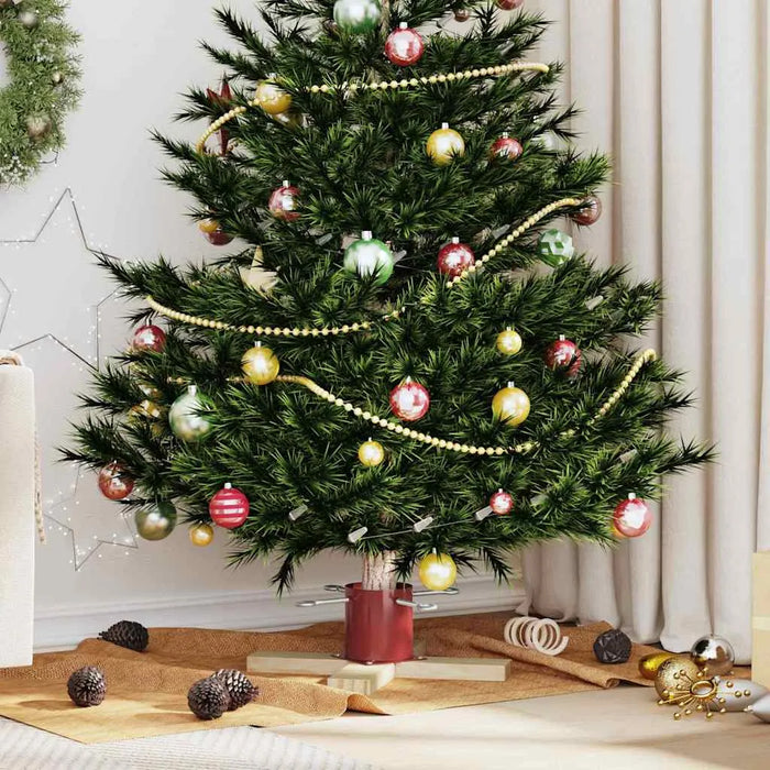 Decorated Christmas tree with red, green, and gold baubles, gold beads, pine cones, and festive indoor setting