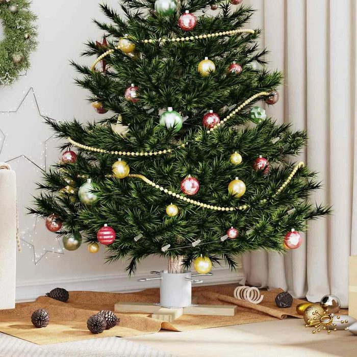Decorated Christmas tree with red, gold, and green ornaments and golden bead garland in cozy living room