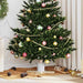 Decorated Christmas tree with red, gold, and green ornaments and golden bead garland in cozy living room