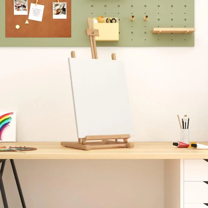 Solid pinewood table top easel with blank canvas on a desk in a modern art workspace