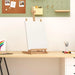 Solid pinewood table top easel with blank canvas on a desk in a modern art workspace