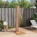 Solid teak outdoor garden shower with stainless steel fixtures on a wooden deck, lounge chair and towels nearby