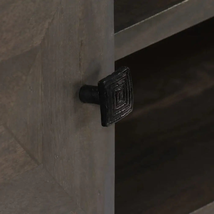 Close-up of a black square metal drawer knob on dark brown wooden furniture at Little and Giant Explorers