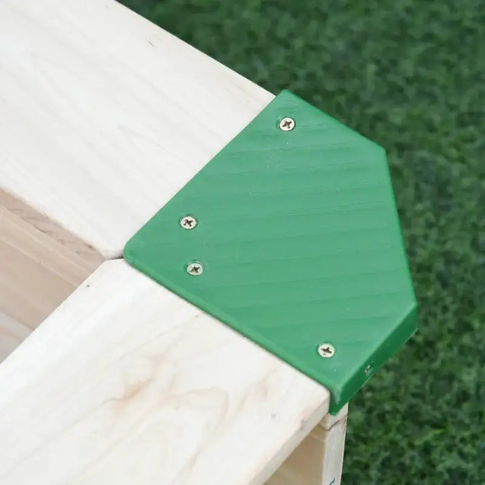 Close-up of square wooden sandbox corner with green plastic bracket on grass