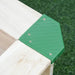 Close-up of square wooden sandbox corner with green plastic bracket on grass
