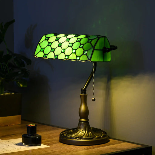 Green stained glass lamp on a wooden table with a dark background