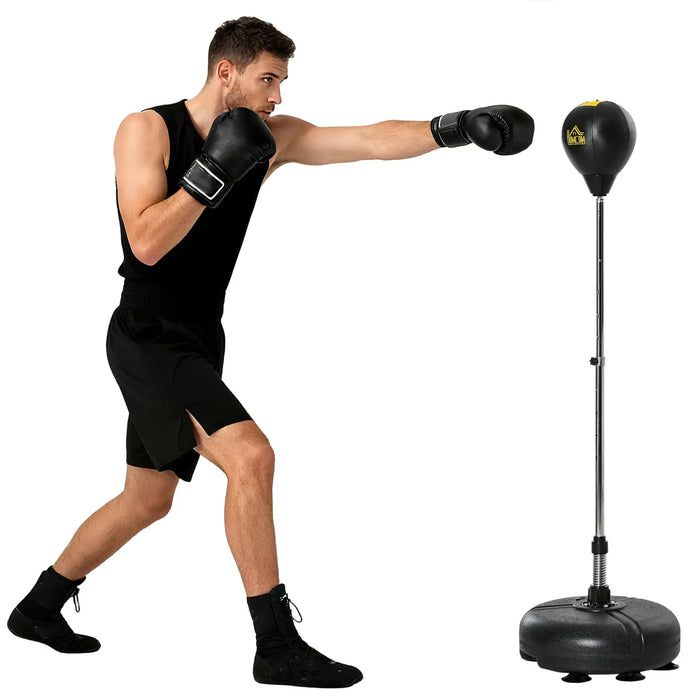 Man in black boxing gloves and attire punching adjustable freestanding punching bag