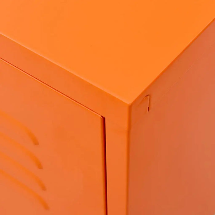 Close-up of orange steel TV cabinet corner with smooth finish and door edge