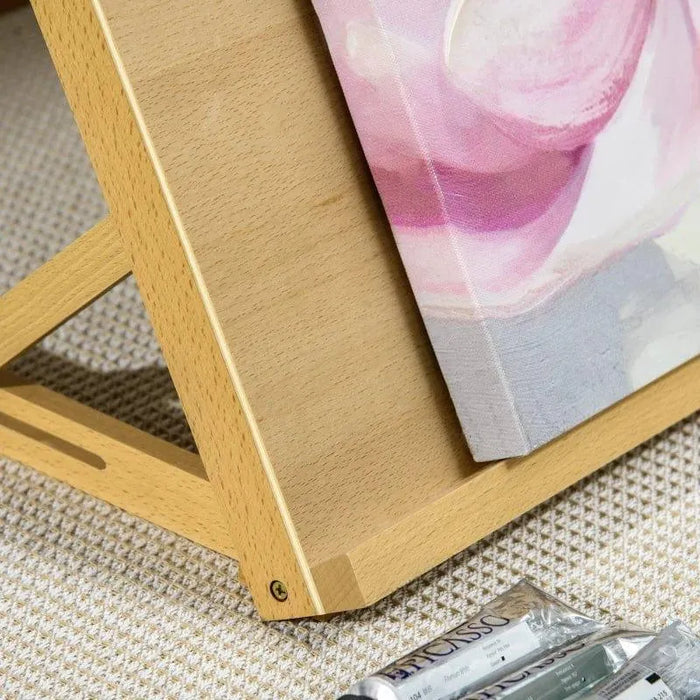 Beechwood tabletop easel with canvas and paint tubes on a textured surface