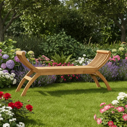 Teak outdoor wooden garden bench with curved armrest design surrounded by lush colorful flowers and green grass