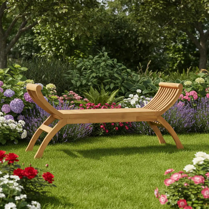 Teak outdoor wooden garden bench with curved armrest design surrounded by lush colorful flowers and green grass