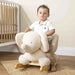 Toddler on plush ecru elephant rocker with wooden base in a nursery setting